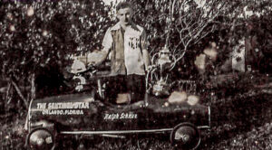 Boy Snuffy behind his Soapbox derby car with his trophys