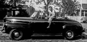Snuffy sitting on his new car shirtless