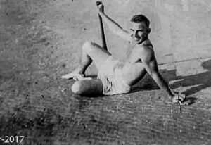 Snuffy sitting in his bathing suite on the beach