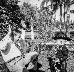 Snuffy with his hands up playing with boy Steven in a cowbow attireholding guns